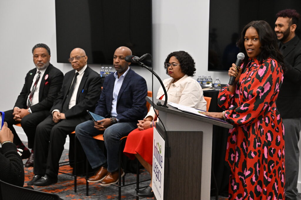 Director, Community Outreach, Ieesha Johnson speaks behind a podium during the Immortal Like Her panel discussion.