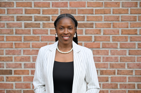 Director, Community Outreach, Ieesha Johnson, stands in front of Infinite Legacy's office smiling.